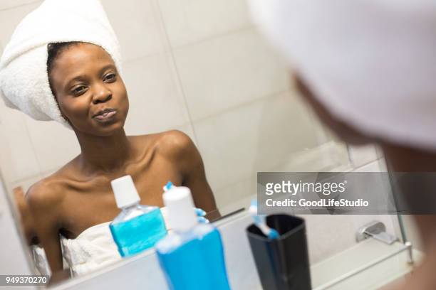 junge afrikanische frau mit mundwasser - mouthwash stock-fotos und bilder