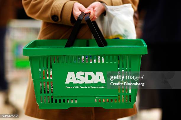 Shopper carries her purchases at an Asda store in Leyton, east London, U.K., on Wednesday, Jan. 14, 2009. Asda, Wal-Mart Stores Inc.'s...