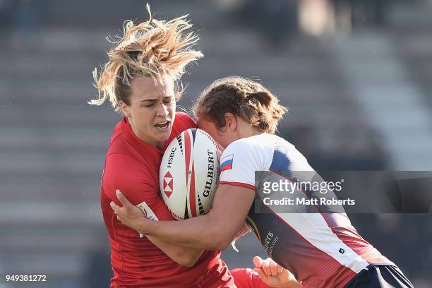 Julia Greenshields of Canada is tackled on day one of the HSBC Women's Rugby Sevens Kitakyushu Pool match between Canada and Russia at Mikuni World...