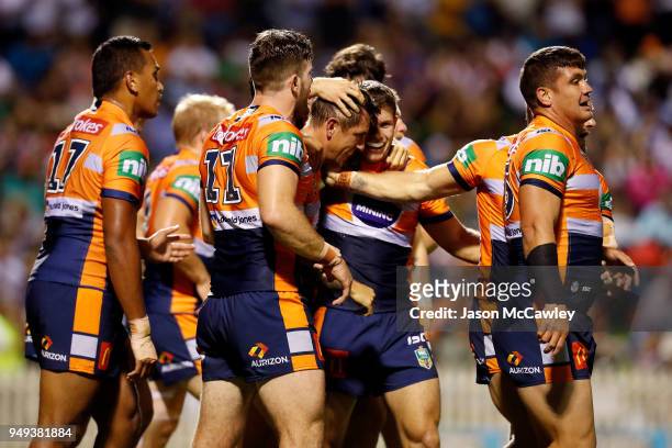 Mitchell Pearce of the Knights celebrates with team mates after scoring a try during the round seven NRL match between the Wests Tigers and the...