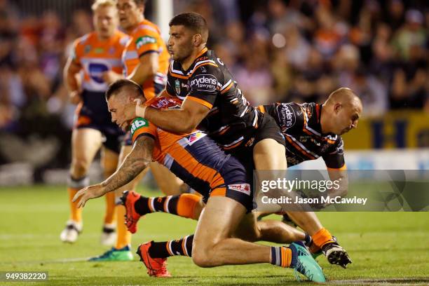 Shaun Kenny-Dowall of the Knights is tackled by Alex Twal of the Tigers during the round seven NRL match between the Wests Tigers and the Newcastle...