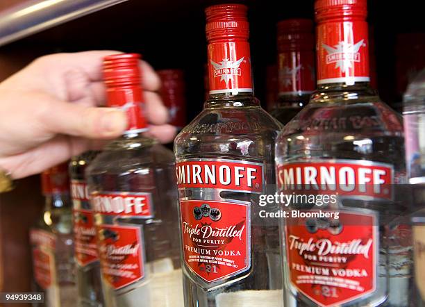 Customer takes a bottle of Smirnoff Vodka, a Diageo product, from a shelf at an off licence, in Hornchurch, U.K., on Thursday, Feb. 12, 2009. Diageo...