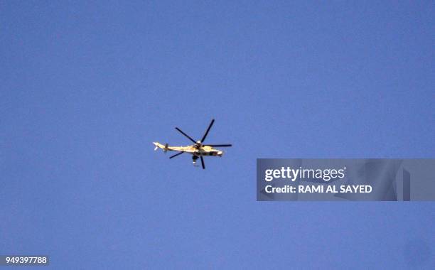 Syrian air force Mil Mi-24 helicopter gunship flies over the Palestinian camp of Yarmuk on the southern outskirts of the Syrian capital Damascus on...