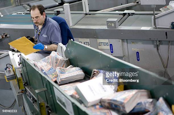Postal worker Hugh Fixman sorts mail by zip code before delivery at the U.S. Postal Service Mid-Island Processing and Distribution Center in...
