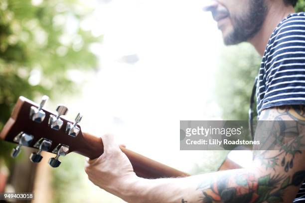 man playing guitar - lilly roadstones stock pictures, royalty-free photos & images