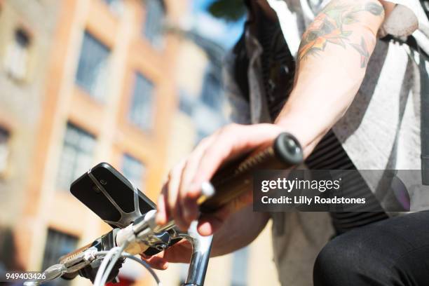 man using mobile phone on bicycle - lilly roadstones stock pictures, royalty-free photos & images
