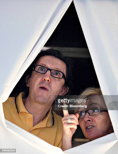 Couple looks out from a window of the Metropark Hotel in Hong Kong, China, on Friday, May 8, 2009. 286 guests and staff at the Metropark Hotel were...
