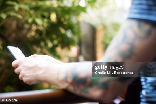 man using mobile phone while holding guitar (close up) - lilly roadstones stock pictures, royalty-free photos & images