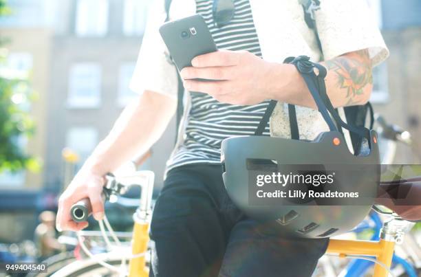 man using mobile phone while leaning on bicycle - lilly roadstones stock pictures, royalty-free photos & images