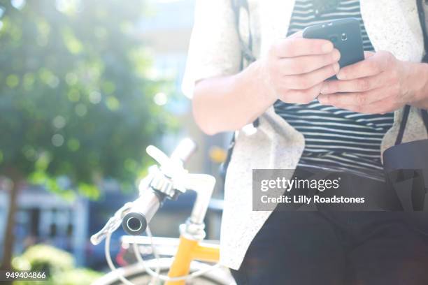 man using mobile phone while leaning on bicycle - lilly roadstones stock pictures, royalty-free photos & images