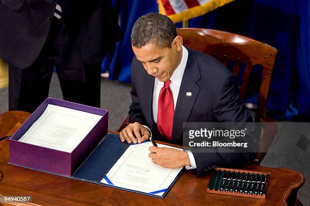 President Barack Obama signs an economic stimulus package into law inside the Museum of Nature and Science in Denver, Colorado, U.S., on Tuesday,...