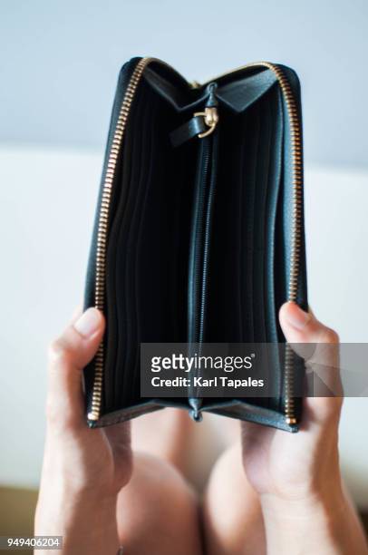 a woman is holding an empty wallet - empty wallet stock pictures, royalty-free photos & images