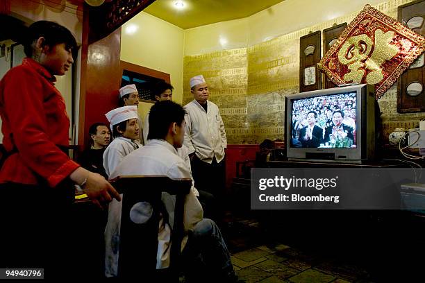 Waiters and cooks watch a television program during the Chinese New Year celebrations in their restaurant in Beijing, China, on Sunday, Jan. 26,...