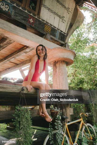 woman sitting near traditional sumatra house - swimwear stock pictures, royalty-free photos & images