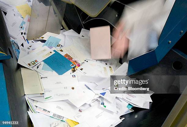 Incoming mail is loaded into a bin to be automatically sorted at the U.S. Postal Service Mid-Island Processing and Distribution Center in Melville,...