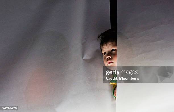 Boy looks out from a window of the Metropark Hotel in Hong Kong, China, on Friday, May 8, 2009. 286 guests and staff at the Metropark Hotel were...