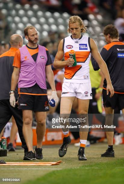 Nick Haynes of the Giants talks to trainers after a collision during the 2018 AFL round five match between the St Kilda Saints and the GWS Giants at...