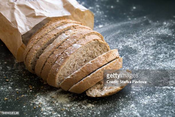 fresh sliced whole grain loaf of bread - volkorentarwe stockfoto's en -beelden