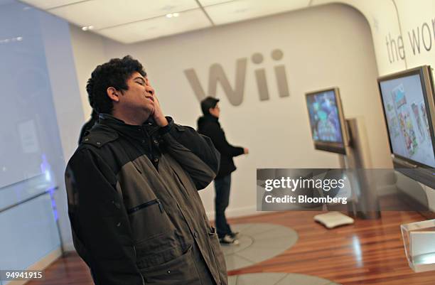 Michael Acosta reacts to a bad putt as he plays Tiger Woods PGA Tour "09 on a Nintendo Wii inside the Nintendo World store in New York, U.S., on...