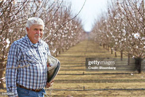 Bill Mathewson, a beekeeper from Bakersfield, stands for a photo in a blooming almond orchard in Wasco, California, U.S., on Friday, Feb. 20, 2009....