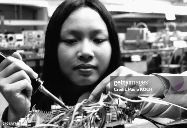 Jeune ouvrière faisant de la soudure dans l'usine d'électronique AMREX, à Hong Kong.