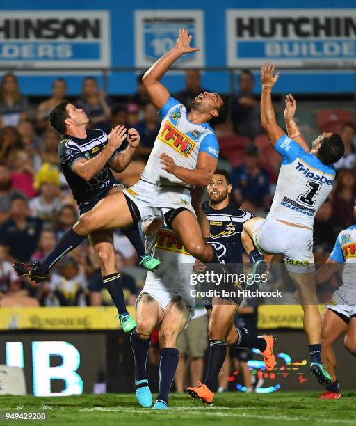 Lachlan Coote of the Cowboys contetsts a high ball with Ryan James of the Titans and Michael Gordon of the Titans during the round seven NRL match...