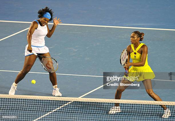 Venus Williams of the United States, right, looks on as her sister Serena returns the ball to Daniela Hantuchova of Slovakia and Ai Sugiyama of Japan...