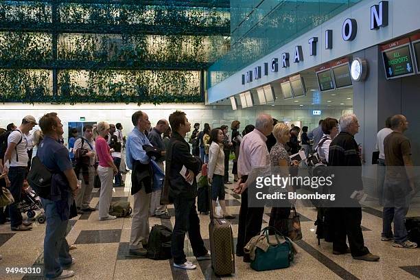Passengers line up at the Immigration counter upon arrival, at Changi airport in Singapore, on Monday, April 27, 2009. Singapore has stepped up...