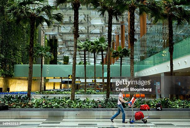 Passenger leaves after picking up baggage at a carousel, at Changi airport in Singapore, on Monday, April 27, 2009. Singapore has stepped up...