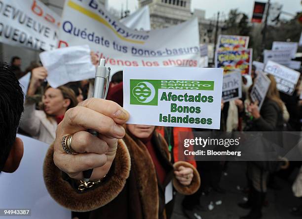 Protestor holds up a sign which reads 'Banco Espirito Santo, Affected by Islandic bonds' during a demonstration in front of the Central Bank of Spain...