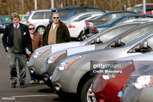 Salesman, left, shows customers Nissan vehicles on the Fred Beans dealership lot in Doylestown, Pennsylvania, U.S., on Saturday, Feb. 28, 2009....