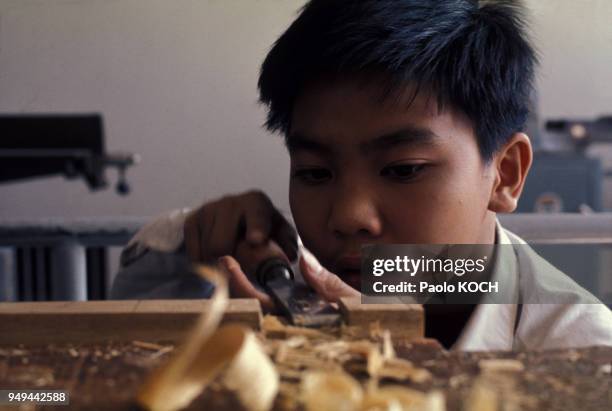 Enfant pendant un cour de menuiserie à l'école, à Hong Kong.