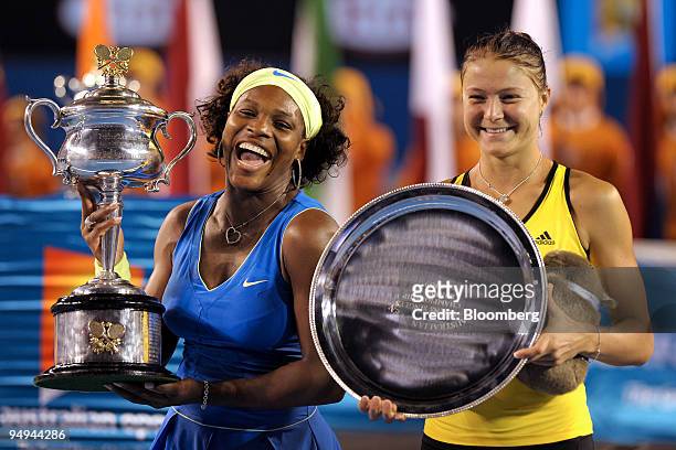 Serena Williams of the U.S., left, holds up the championship trophy as Dinara Safina of Russia displays the runner-up plaque following their women's...