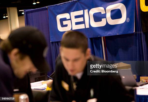 Chad Hickman, right, talks with an attendee at the Geico Corp., a subsidiary of Berkshire Hathaway Inc., booth during Berkshire?s annual shareholder...