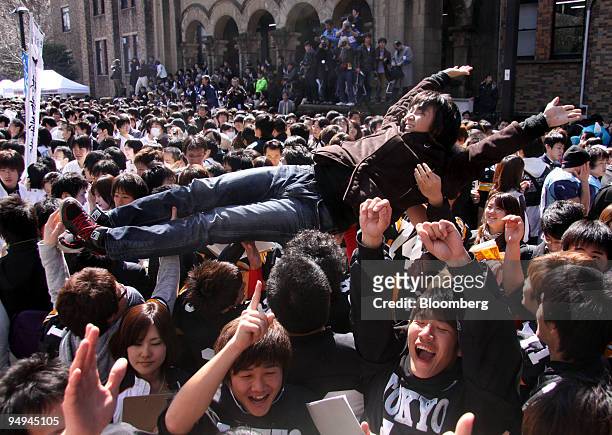 Successful applicant is tossed in the air by current students at The University of Tokyo in Tokyo, Japan, on Tuesday, March 10, 2009. The University...