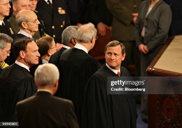 John Roberts, chief justice of the U.S. Supreme Court, right, looks over the crowd prior to U.S. President Barack Obama's, unseen, first address to a...