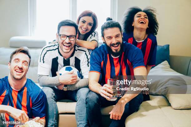 grote groep vrienden plezier tijdens het kijken naar voetbalspel vanuit huis - pre game stockfoto's en -beelden