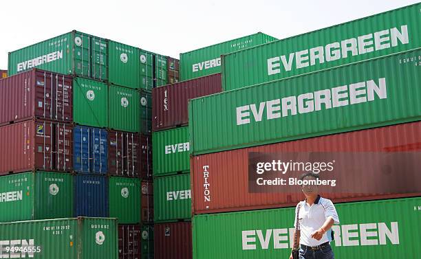 Pedestrian walks past Evergreen Marine Corp. Containers stacked at the company's container terminal in Taoyuan, Taiwan, on Tuesday, Sept. 1, 2009....