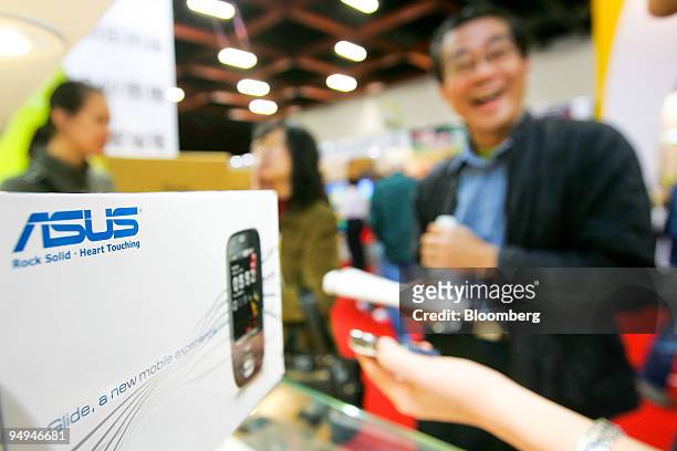 Man inspects Asustek Computer Inc. Mobile phones at an expo in Taipei, Taiwan, on Thursday, Feb. 12, 2009. Asustek, the world's largest supplier of...