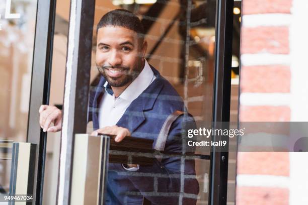 mixed race man opening exterior door, leaving work - abrir a porta sair imagens e fotografias de stock