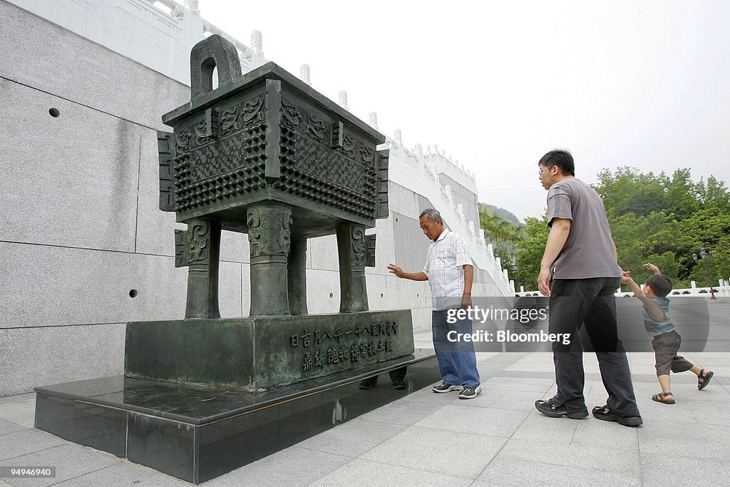 Visitors look at an ancient Chinese cooking vessel at the Ta