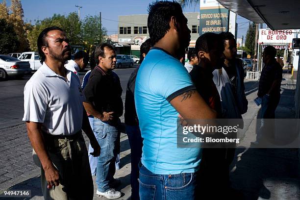 Unemployed men look at job postings outside of the National Employment Service in Aguascalientes, Mexico, on Tuesday, March 17, 2009. The auto sector...