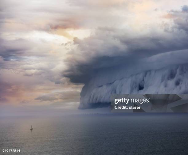 tiny sailing boat and incoming storm - roll stock pictures, royalty-free photos & images