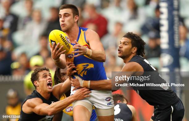 Elliot Yeo of the Eagles is tackled by Ed Curnow and Sam Petrevski-Seton of the Blues during the 2018 AFL round five match between the Carlton Blues...