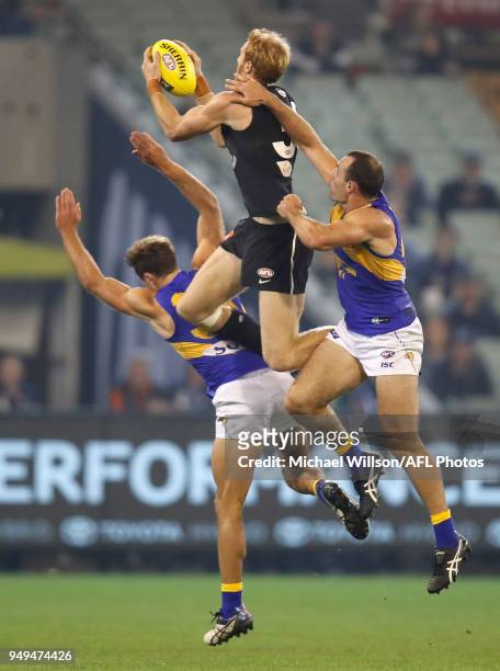 Andrew Phillips of the Blues takes a high mark over Mark Hutchings and Shannon Hurn of the Eagles during the 2018 AFL round five match between the...
