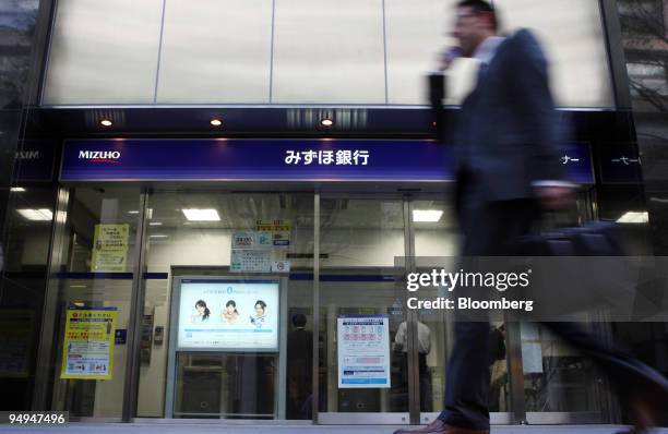 Man walks past a Mizuho Bank Ltd. Branch in Tokyo, Japan, on Thursday, April 23, 2009. Mizuho Financial Group Inc., Japan's second-largest bank by...