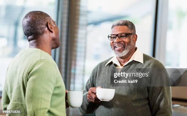 zwei afro-amerikanische männer reden über kaffee - chubby men stock-fotos und bilder