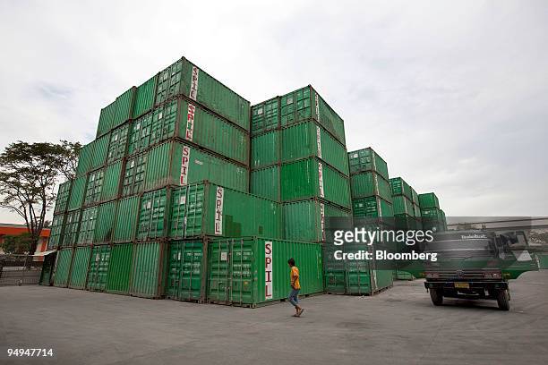 Man walks past shipping containers stored at the main port facility in Jakarta, Indonesia, on Friday, May 15, 2009. Indonesia's economy grew at the...