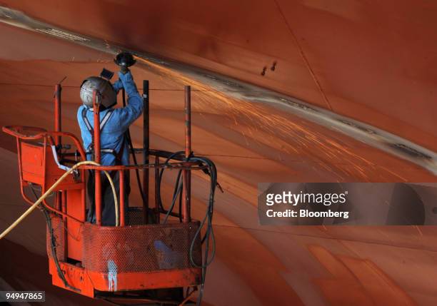 An employee works on a ship under construction at the Hyundai Heavy Industries Co. Shipyard in Ulsan, South Korea, on Thursday, April 23, 2009....