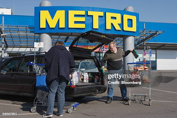 Peter and Ute Geske load their car with purchases at a Metro AG store in Neuss, Germany, on Saturday, March 21, 2009. Metro AG, Germany's largest...